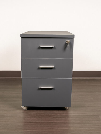 A three-drawer mobile storage unit (Model: 144) made from melamine board, featuring color-customizable drawer fronts and castor wheels, placed on a wooden floor against an olive green wall.